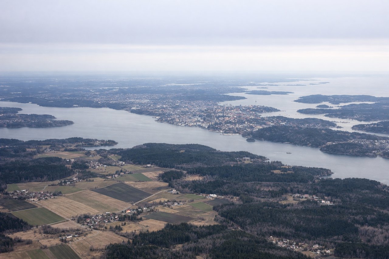Left window seat view during takeoff from Stockholm (ARN) — Stockholm city center and Gamla Stan skyline, the inner Stockholm archipelago islands, Lake Mälaren's eastern bays, and the Baltic Sea coastline beyond Stockholm