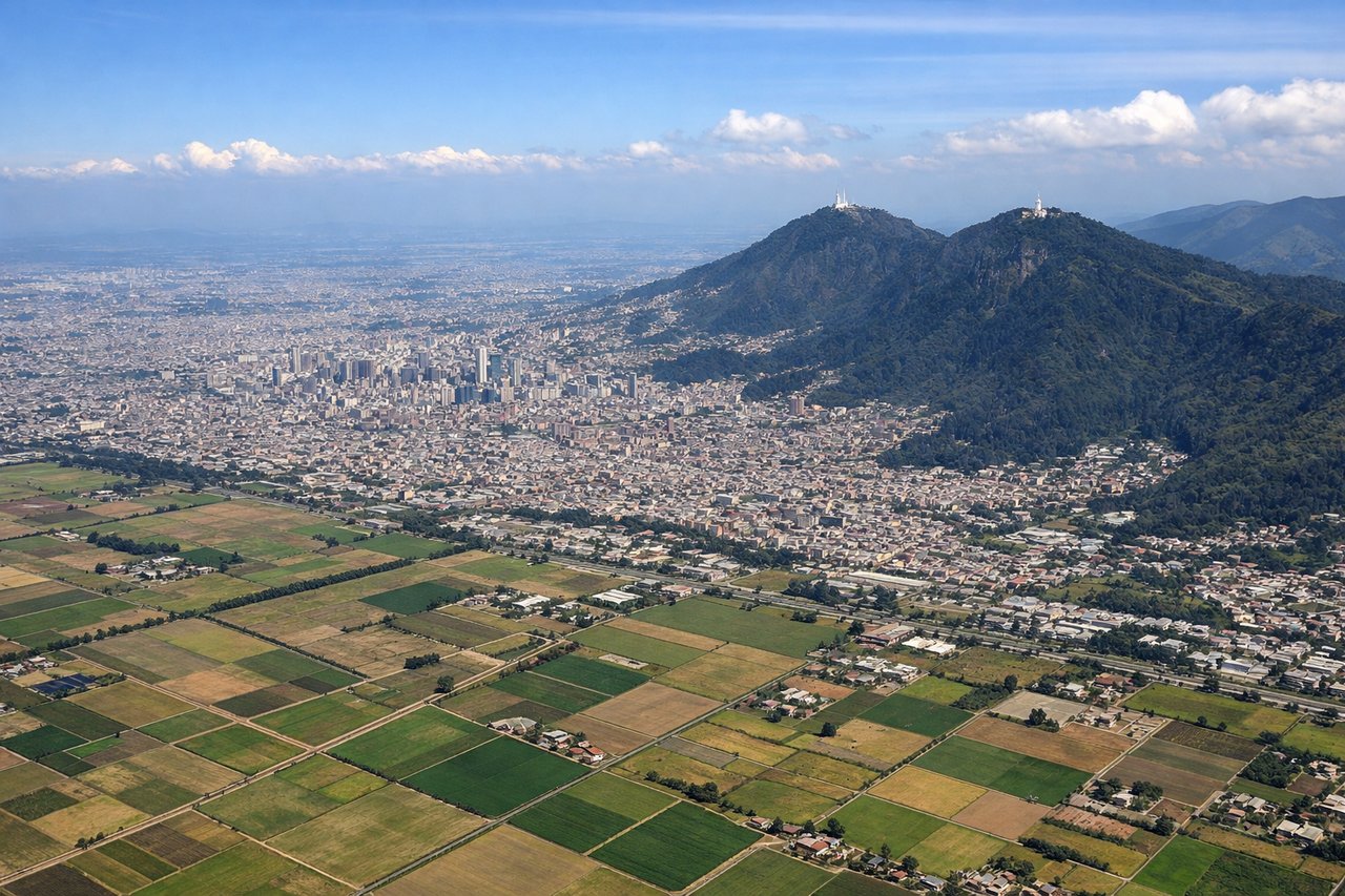 Right window seat view during takeoff from Bogota (BOG) — Cerros Orientales ridge, Monserrate and Guadalupe hilltop sanctuaries, downtown Bogotá skyline, Sabana de Bogotá plateau edge