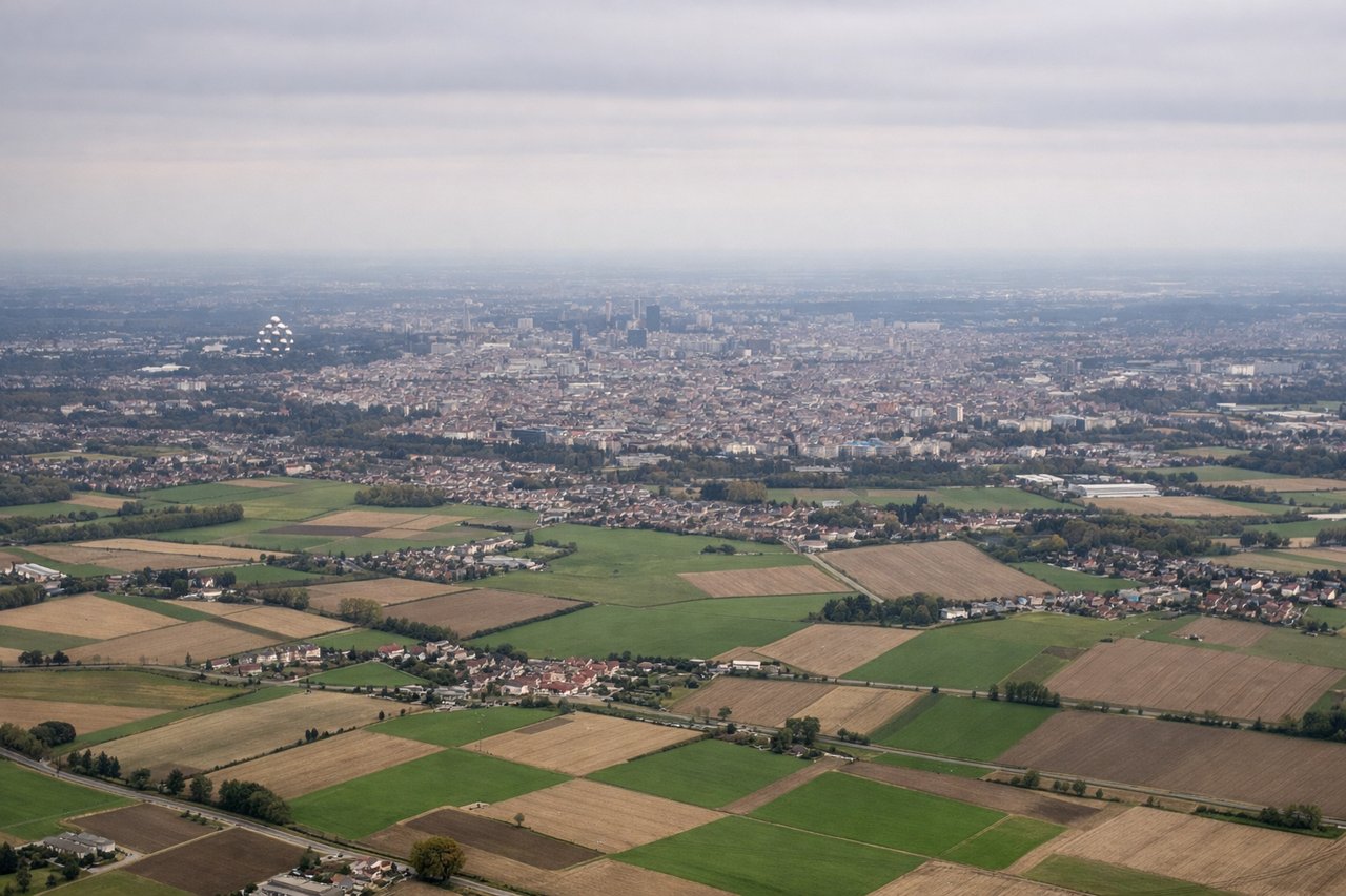Aerial window seat view during takeoff from Brussels (left side) — Brussels city center urban grid, Atomium structure (northwest Brussels), Canal du Centre waterway, Flemish agricultural patchwork north of the city