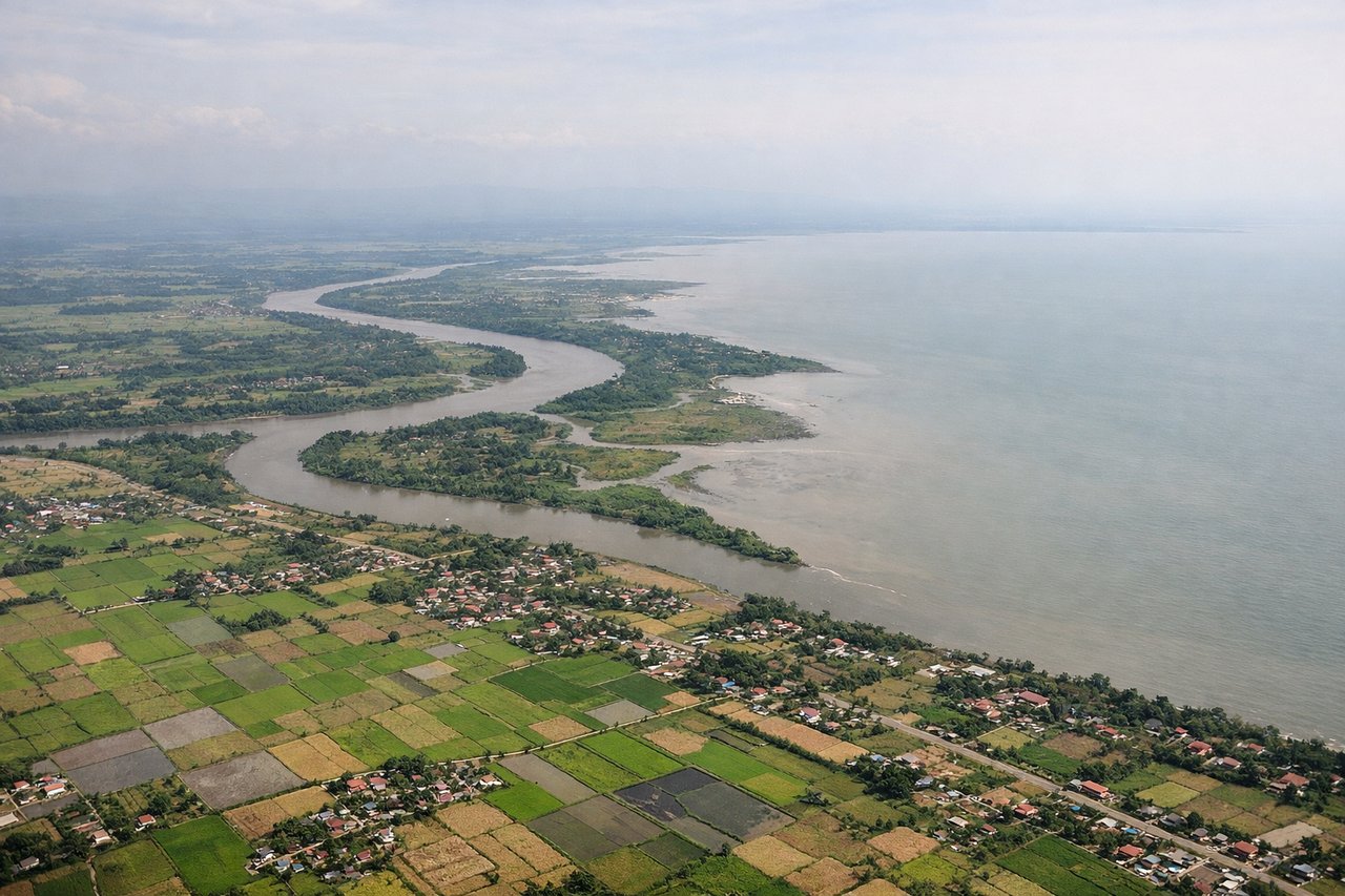 Aerial window seat view during landing at Cebu (left side) — Cebu City skyline and port, Cebu's central mountain range (Busay Hills), Mactan Channel, Mactan Island coastline