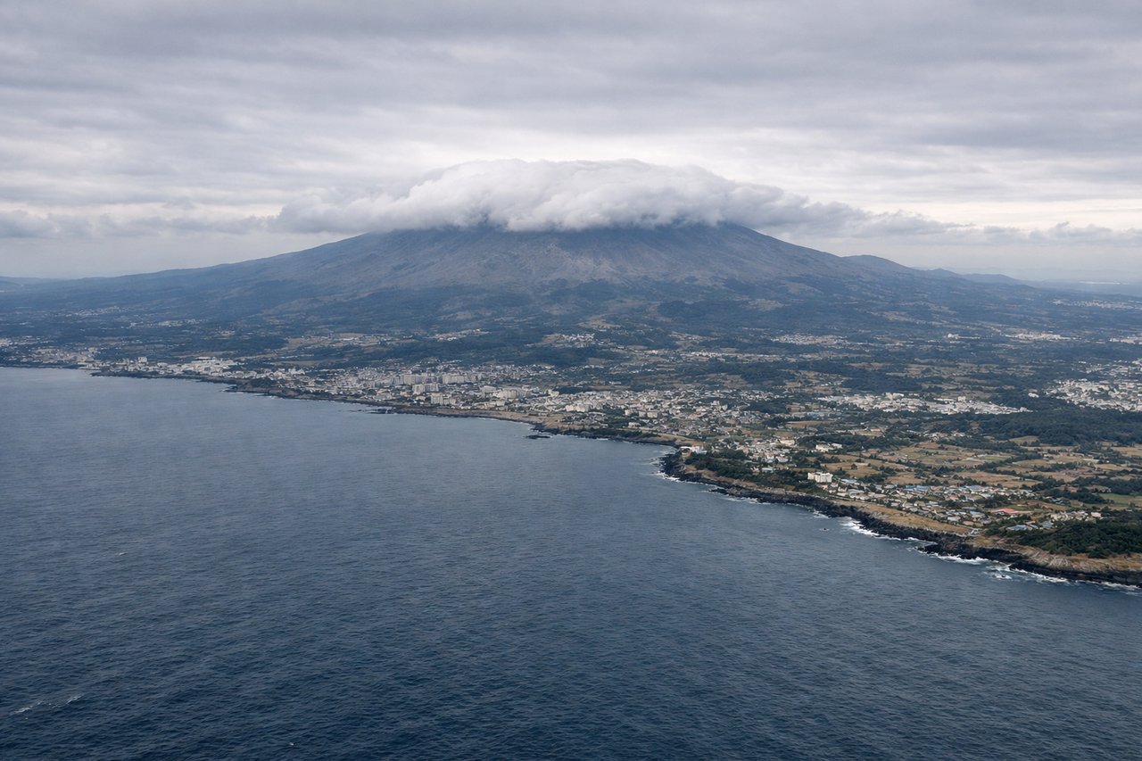 Left window seat view during landing at Cheju (CJU), Hallasan (South Korea's highest peak), Jeju City's coastal sprawl, the rolling volcanic countryside of central Jeju, occasional glimpses of smaller coastal islets to the southwest