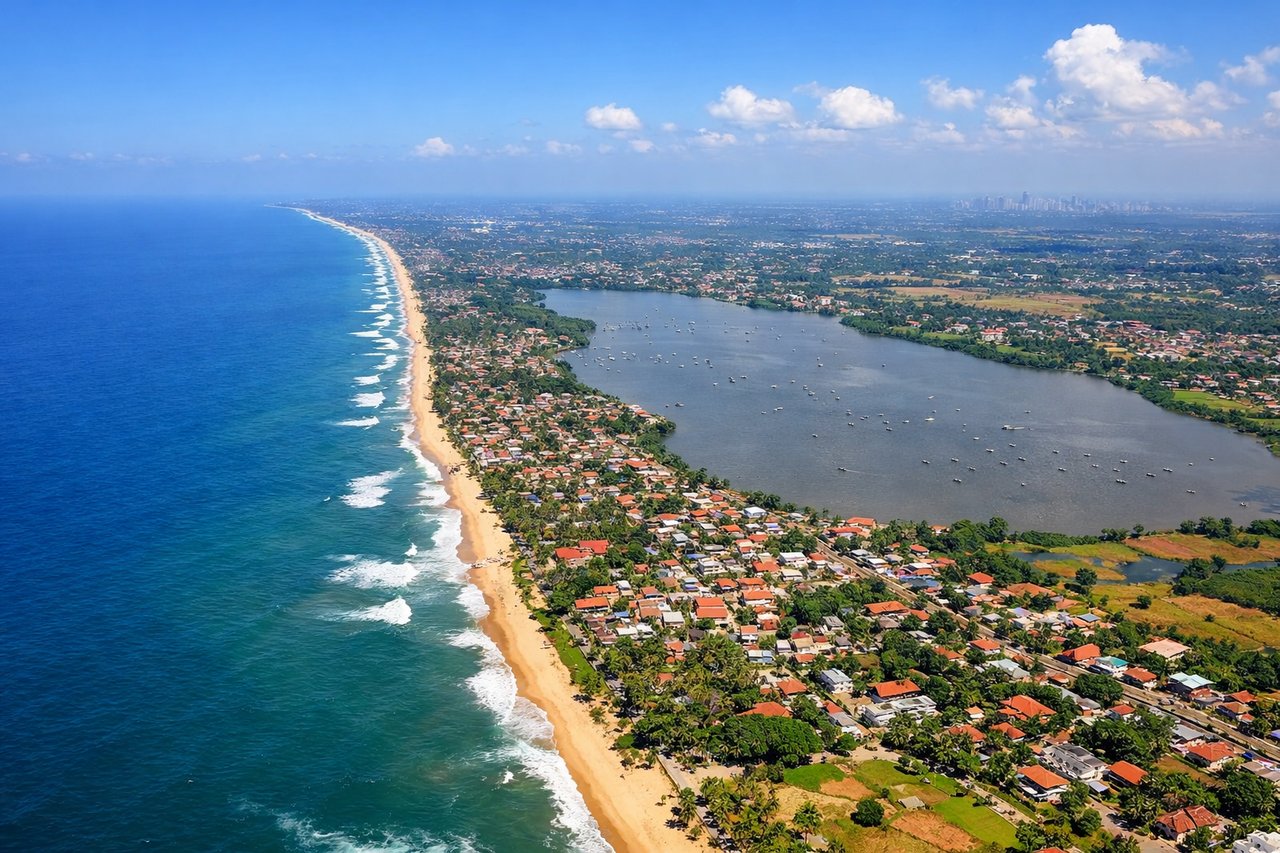 Aerial window seat view during landing at Colombo (left side) — Central highlands ridgelines, tea plantation terraces, Colombo's coastal skyline, Indian Ocean shoreline