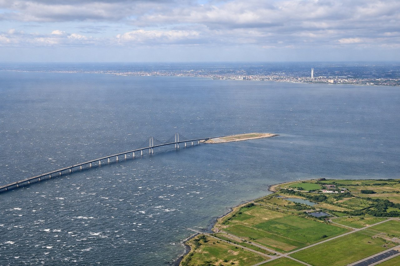 Aerial window seat view during landing at Copenhagen (left side) — Øresund Strait and Malmö waterfront, Danish archipelago and island chains, Møn's white chalk cliffs (visible from altitude on clear days), Copenhagen harbor and Amager Island