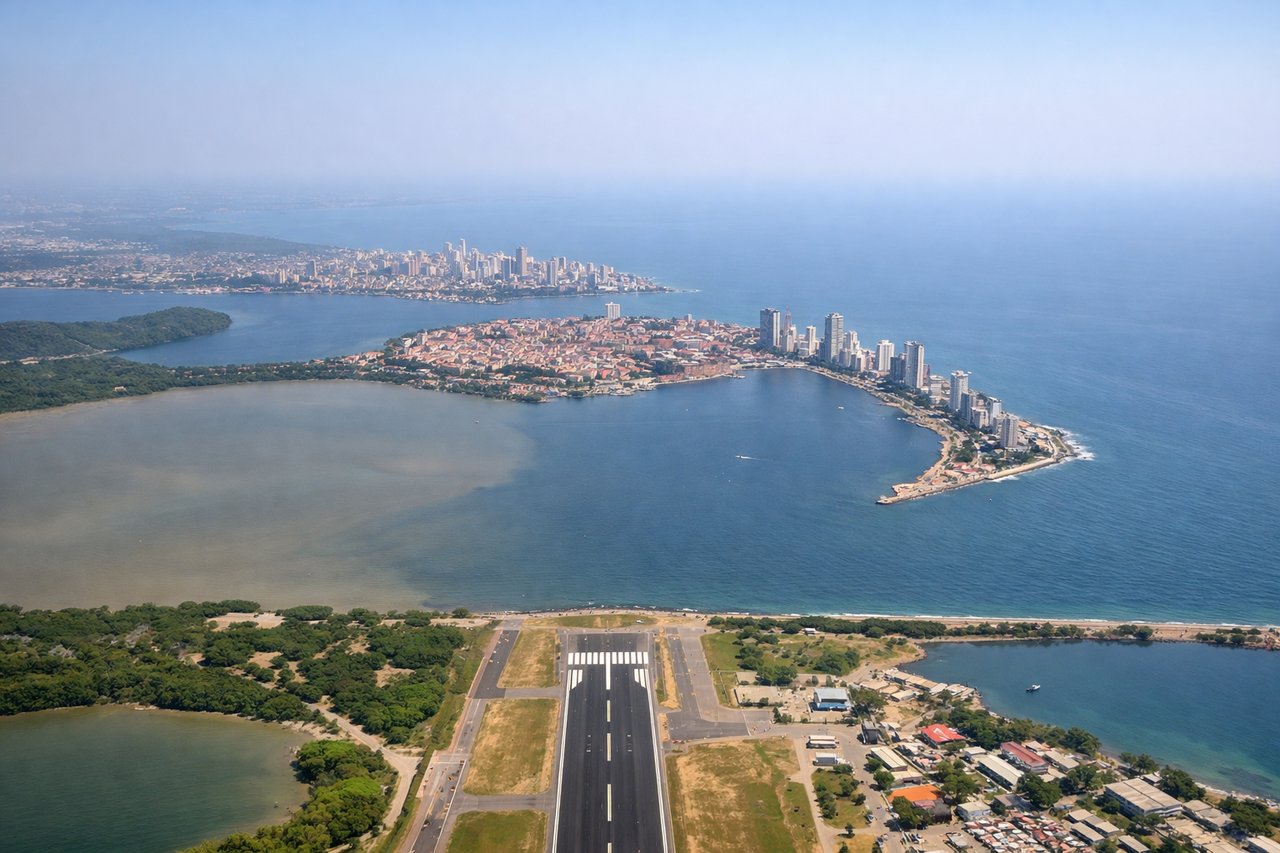 Left window seat view during takeoff from Cartagena (CTG) — Centro Histórico (walled Old City), Bocagrande skyscraper skyline, Cartagena Bay, Tierra Bomba Island