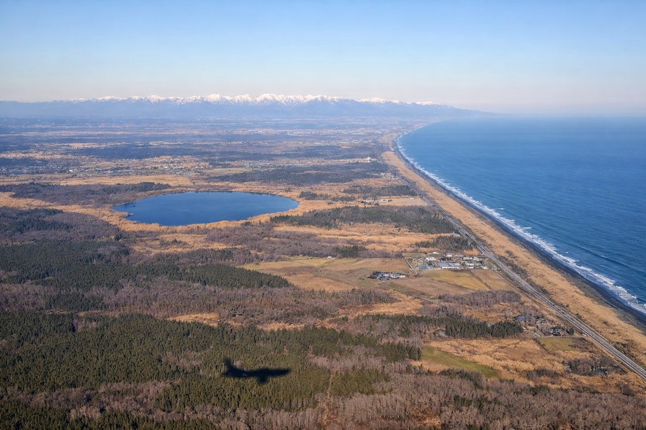 Right window seat view during landing at Sapporo (CTS) — Mount Eniwa, Lake Shikotsu caldera rim, distant Mount Yotei, Ishikari plain farmland