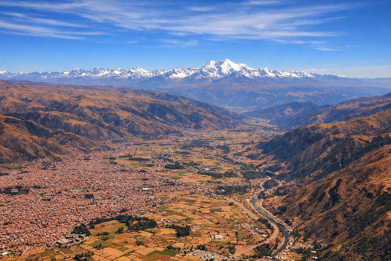 Aerial window seat view during landing at Cuzco (right side) — Urubamba River canyon, Sacred Valley agricultural terraces, Andes peaks surrounding Cuzco basin, Cuzco city at 11,000 feet elevation