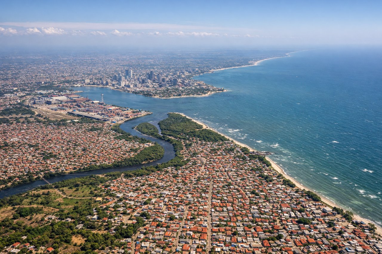 Left window seat view during takeoff from Dar Es Salaam (DAR) — Dar es Salaam harbor and port, Msasani Bay peninsula, Indian Ocean coastline, Kigamboni ferry crossing area