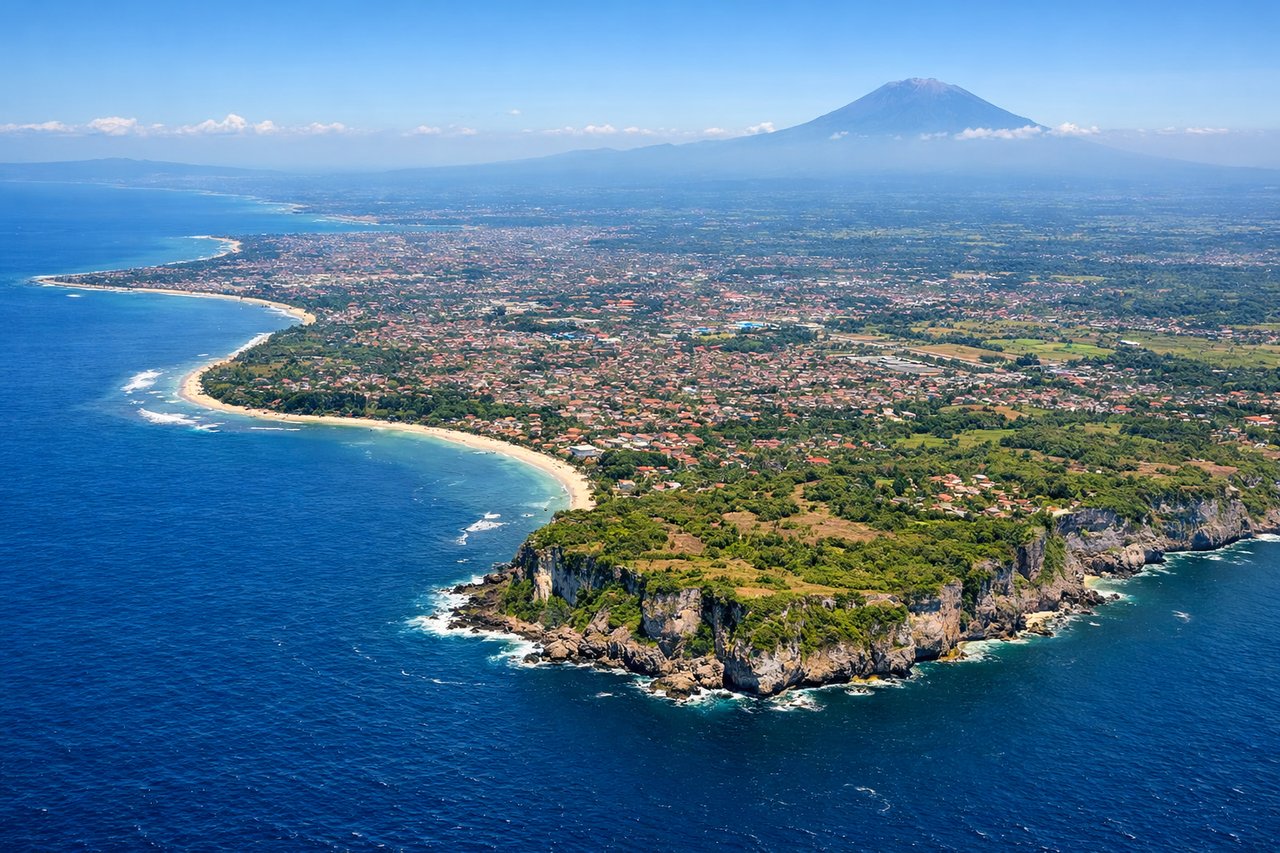 Aerial window seat view during landing at Denpasar (left side) — Mount Agung (3,142 m, visible as a prominent peak on Bali's eastern side), Bali Strait (separating Bali from Lombok), central Bali highlands and rice terraces, Denpasar urban area (southern coast)