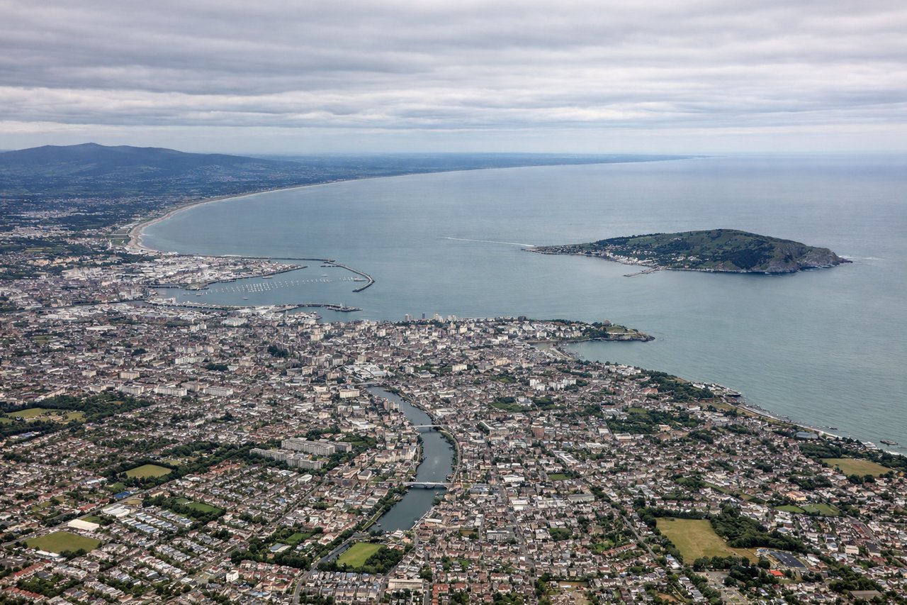Aerial window seat view during takeoff from Dublin (left side) — Dublin Bay, River Liffey and city center, Wicklow Mountains, Irish Sea coastline