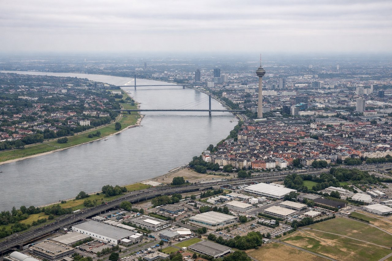 Right window seat view during landing at Duesseldorf (DUS) — Rhine River bend, Düsseldorf skyline with Rheinturm TV tower, Media Harbour district, Ratingen suburb