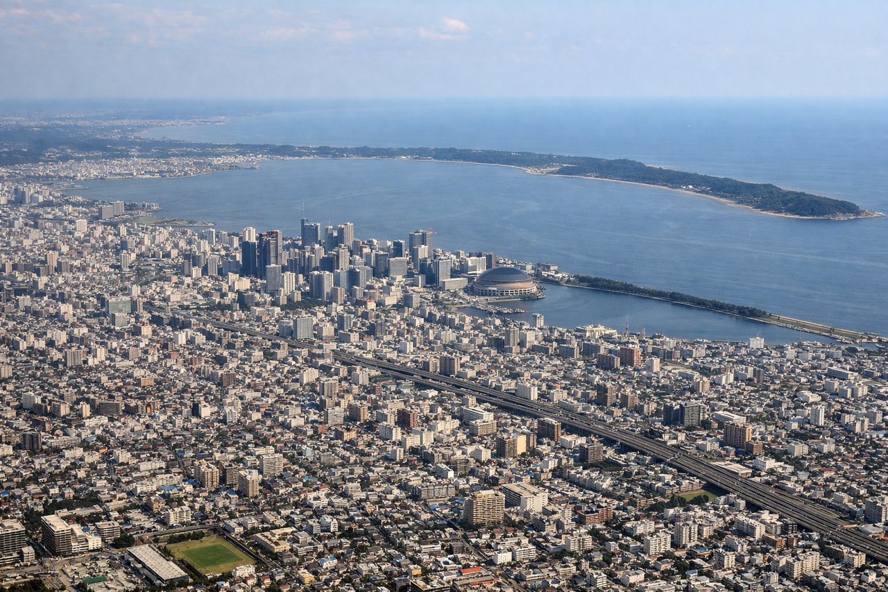 Aerial window seat view during landing at Fukuoka (left side) — Hakata Bay, Fukuoka city skyline, Island City (Kashii), Genkai Sea coastline