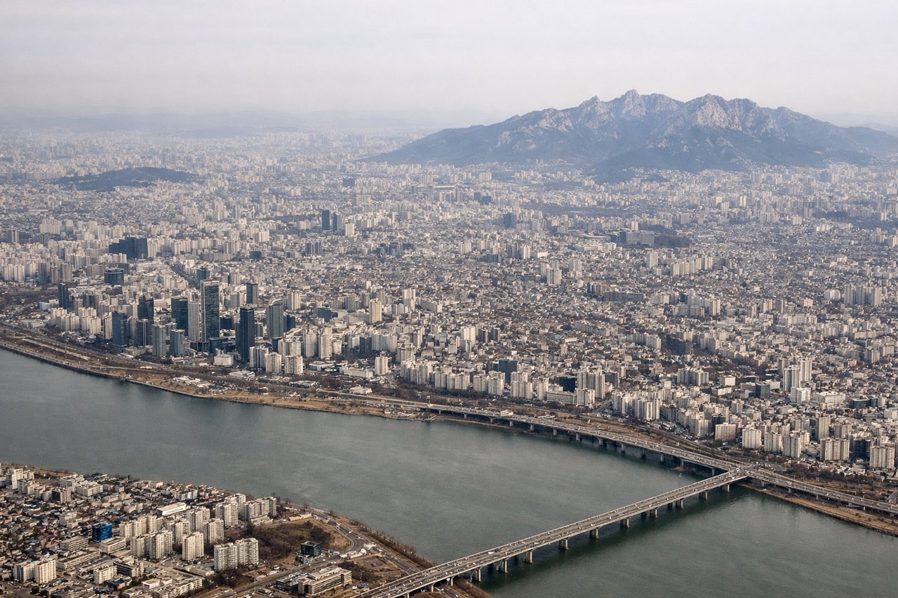 Aerial window seat view during landing at Seoul (right side) — Han River, Seoul skyline (Lotte World Tower, Yeouido), Namsan/N Seoul Tower, Gimpo's riverside approach lights