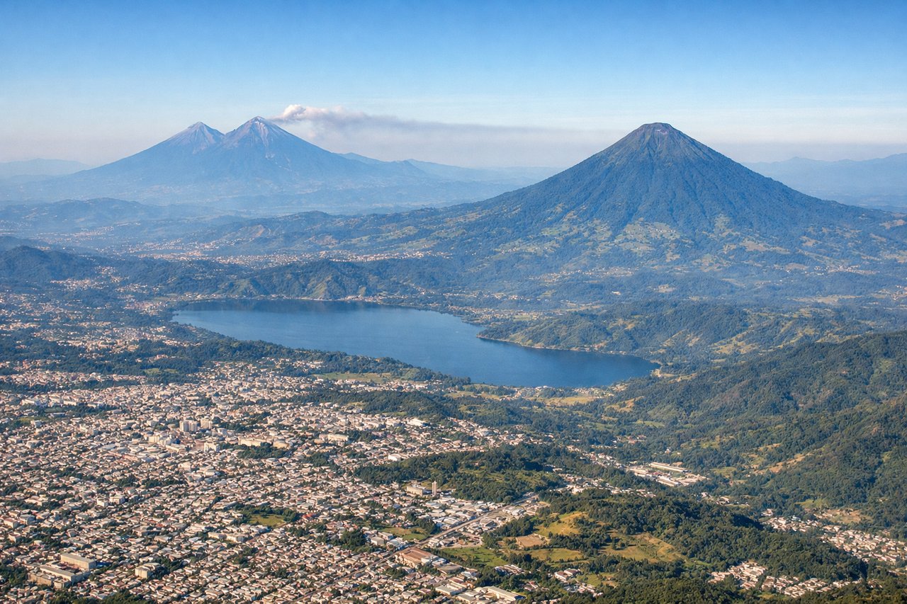 Aerial window seat view during takeoff from Guatemala City (right side) — Sierra de las Minas (northeast), Guatemala City urban sprawl (directly below), Lake Amatitlán (south), Central Highlands plateau