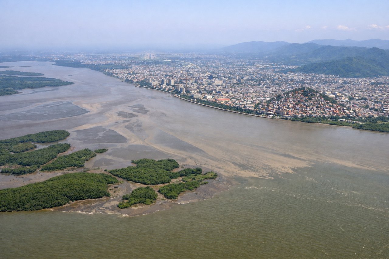 Aerial window seat view during landing at Guayaquil (right side) — Guayas River estuary and mangrove forests, Guayaquil city sprawl along riverbanks, Andes foothills (distant eastern horizon), Salado River confluence