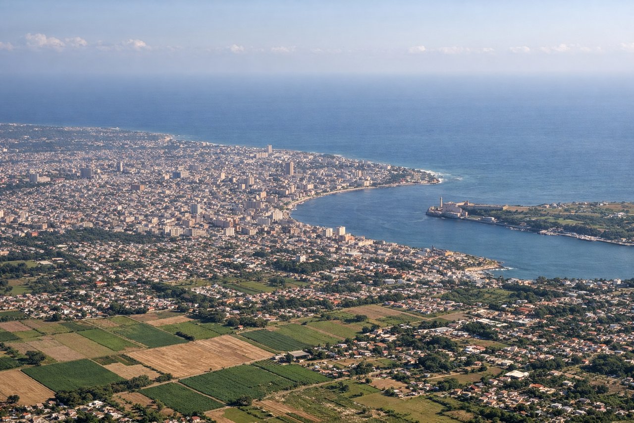 Aerial window seat view during landing at Havana (left side) — Havana Harbor and its narrow entrance channel, Old Havana city grid along the waterfront, the Malecón coastal boulevard, Morro Castle fortification at the harbor mouth