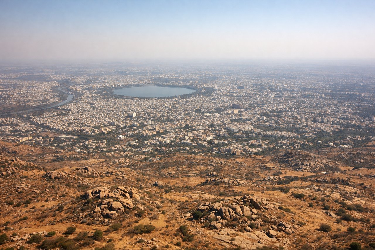 Aerial window seat view during landing at Hyderabad (left side) — Hussain Sagar Lake, Golconda Fort ridge, Hyderabad city skyline, granite boulder outcrops of the Deccan Plateau