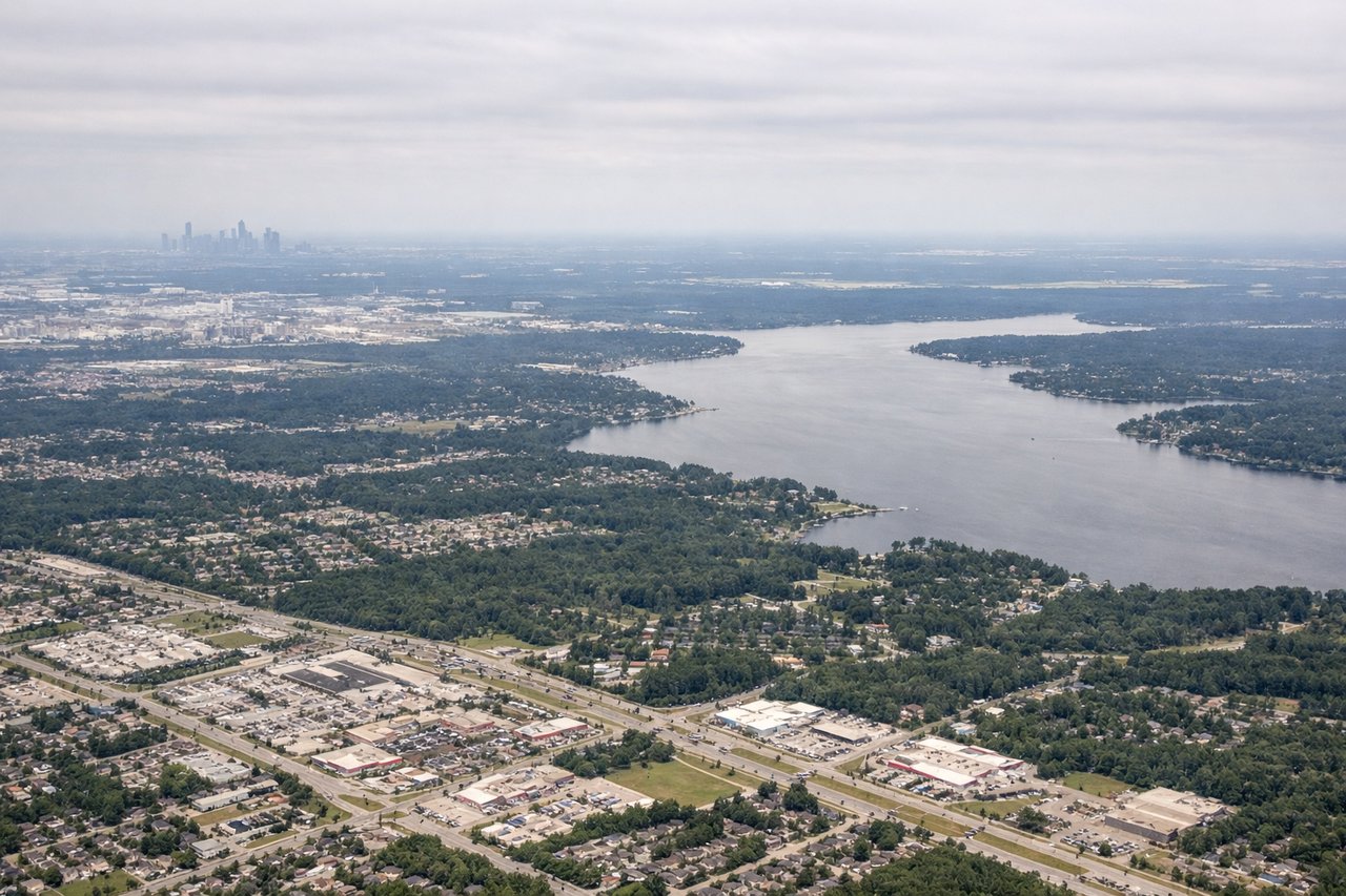 Aerial window seat view during landing at Houston (right side) — Galveston Bay and barrier islands, Houston city grid and downtown skyline, industrial refineries and petrochemical plants along the ship channel, Trinity River delta