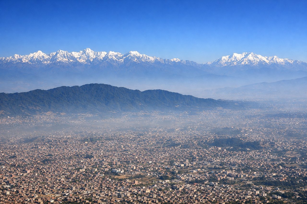 Right window seat view during takeoff from Kathmandu (KTM) — Kathmandu Valley and Bagmati river basin, Chandragiri/Phulchoki hill rim, Langtang Himal range, distant Everest massif (clear-day only)