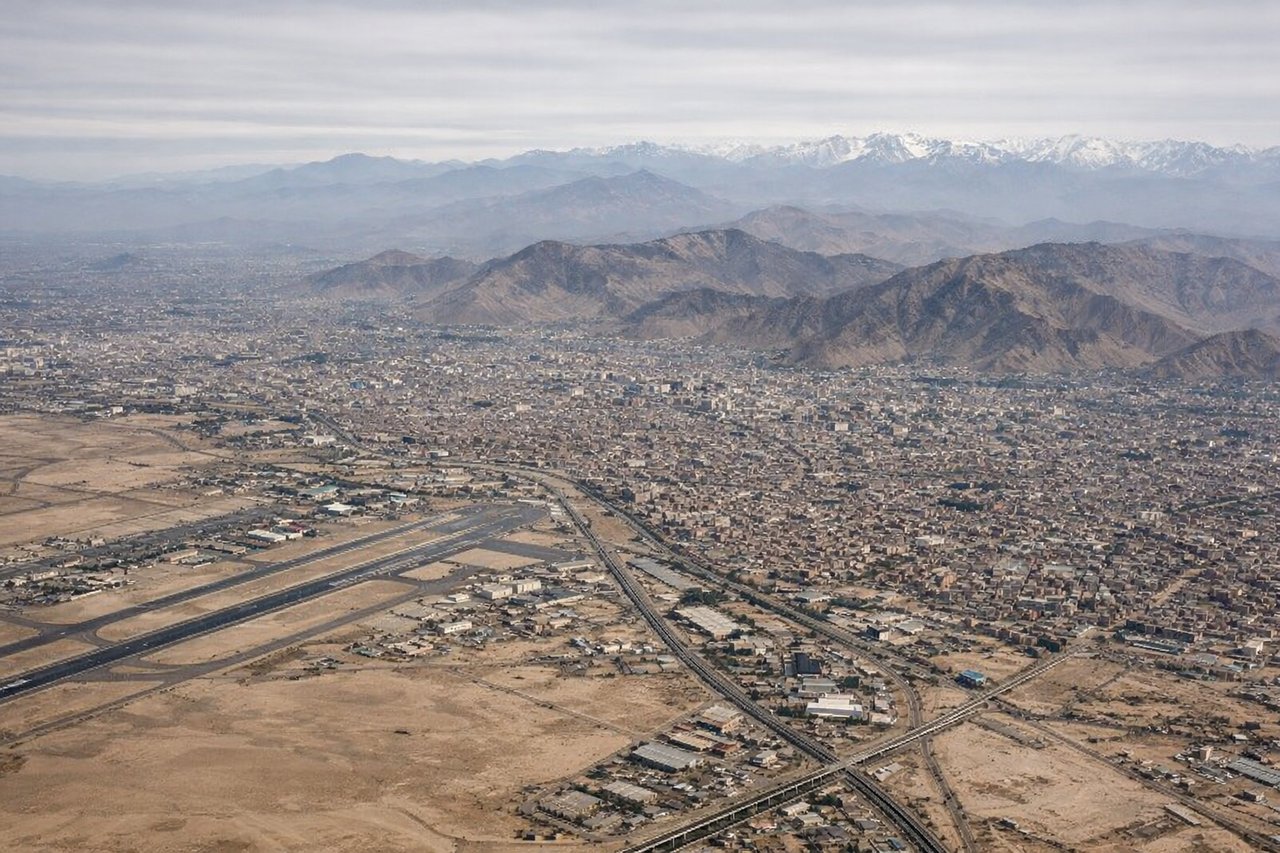 Right window seat view during landing at Lima (LIM) — Pacific Ocean, Callao port and harbor breakwaters, coastal cliffs near La Punta, Lima's coastal urban sprawl