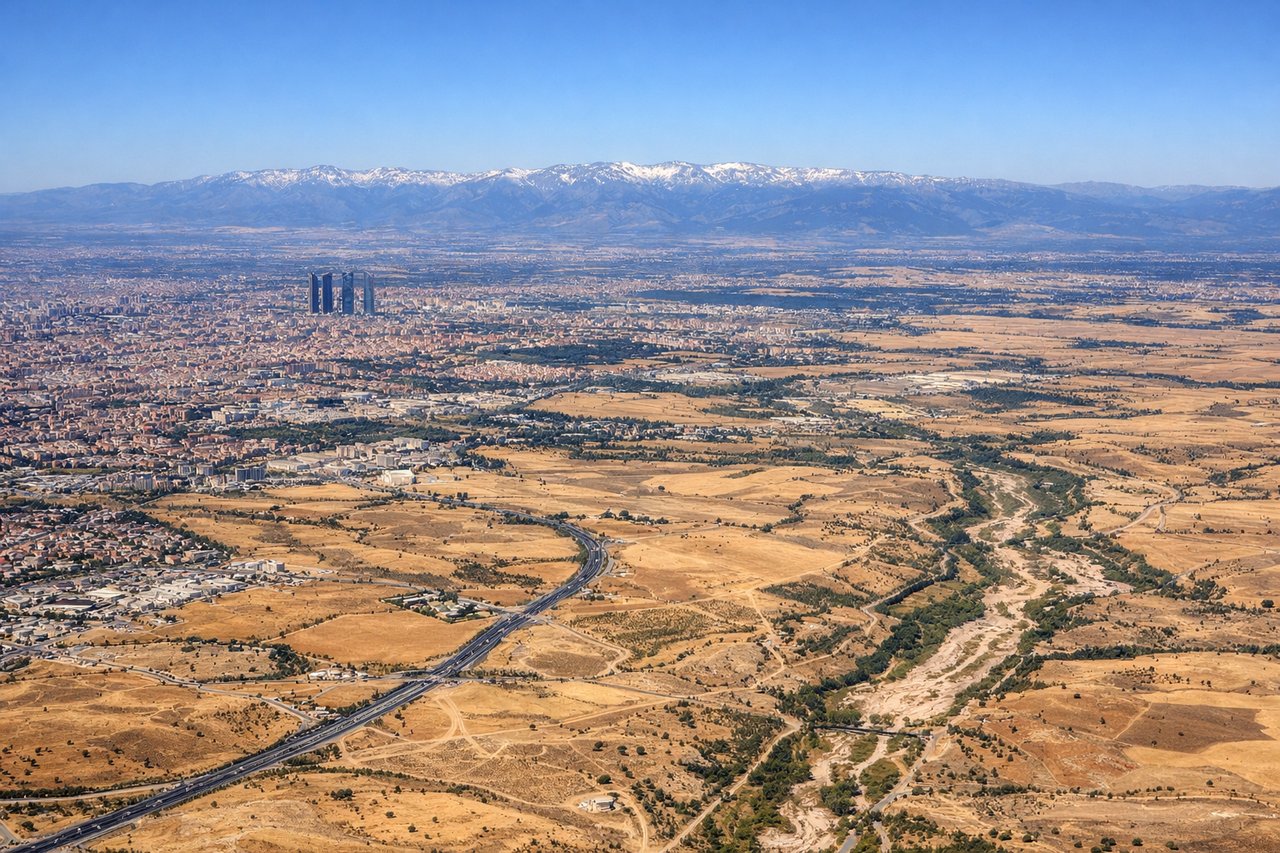 Right window seat view during landing at Madrid (MAD) — Madrid skyline and Cuatro Torres Business Area, Manzanares river corridor, Casa de Campo park, outer suburbs of southern Madrid
