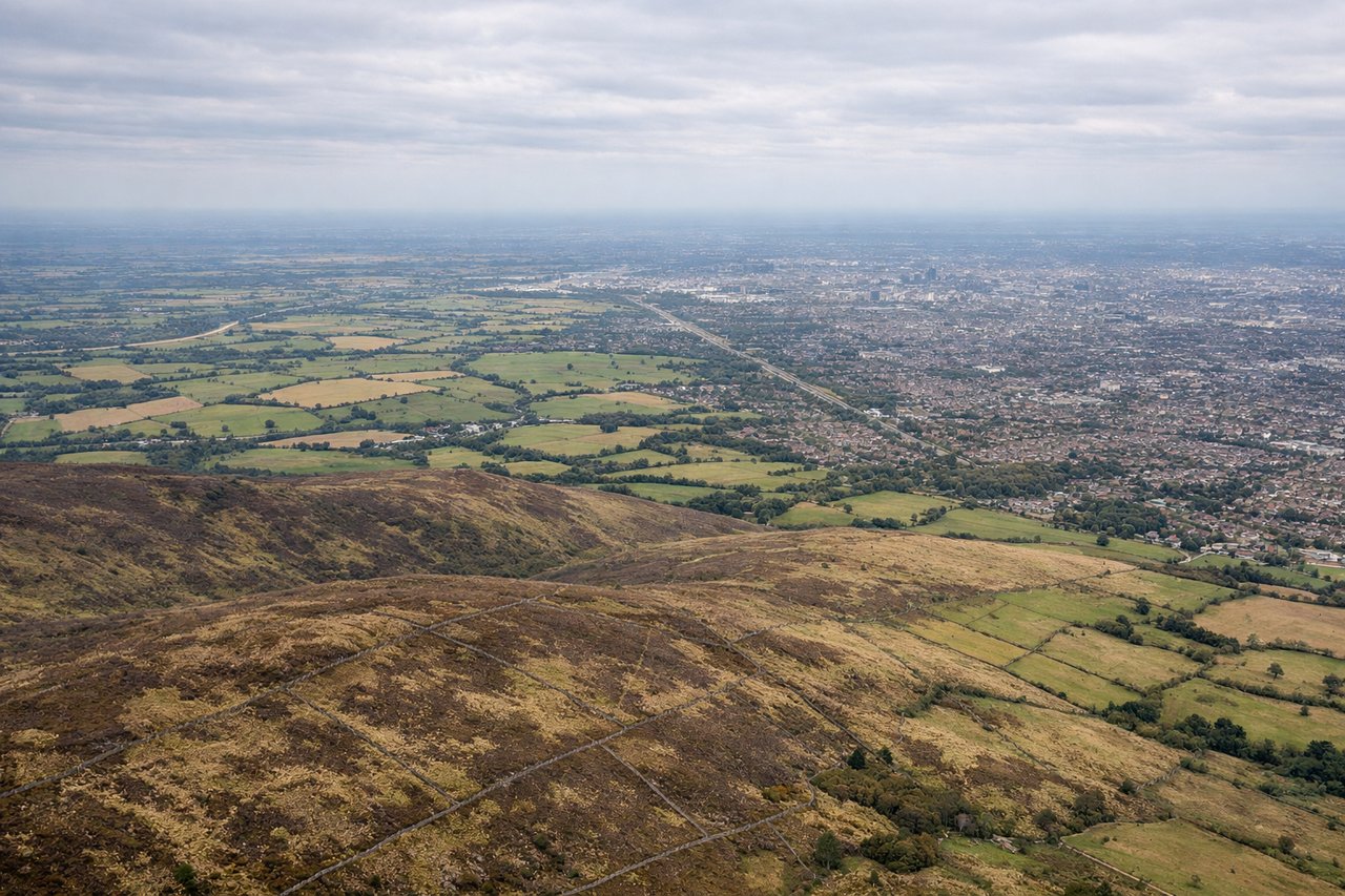 Aerial window seat view during landing at Manchester (right side) — Peak District foothills, Cheshire plain farmland, Manchester's southern suburbs, Manchester Ship Canal