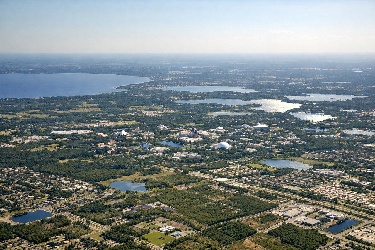Left window seat view during landing at Orlando (MCO) — Downtown Orlando skyline, Central Florida lakes, Walt Disney World area in the distance, Orlando suburban sprawl