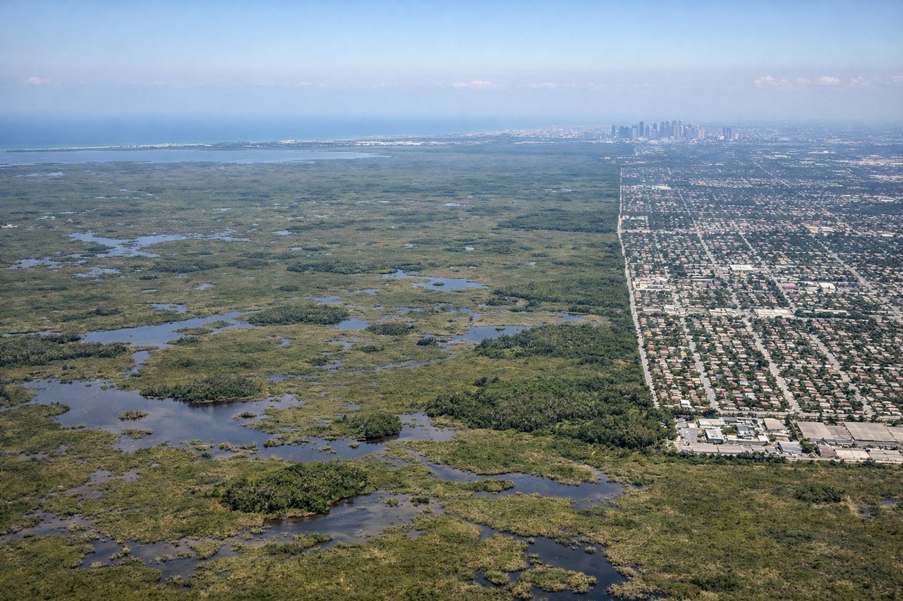 Aerial window seat view during landing at Miami (left side) — Bahamas Great Bahama Bank turquoise shallows, Miami Beach barrier island, Biscayne Bay, Downtown Miami skyline