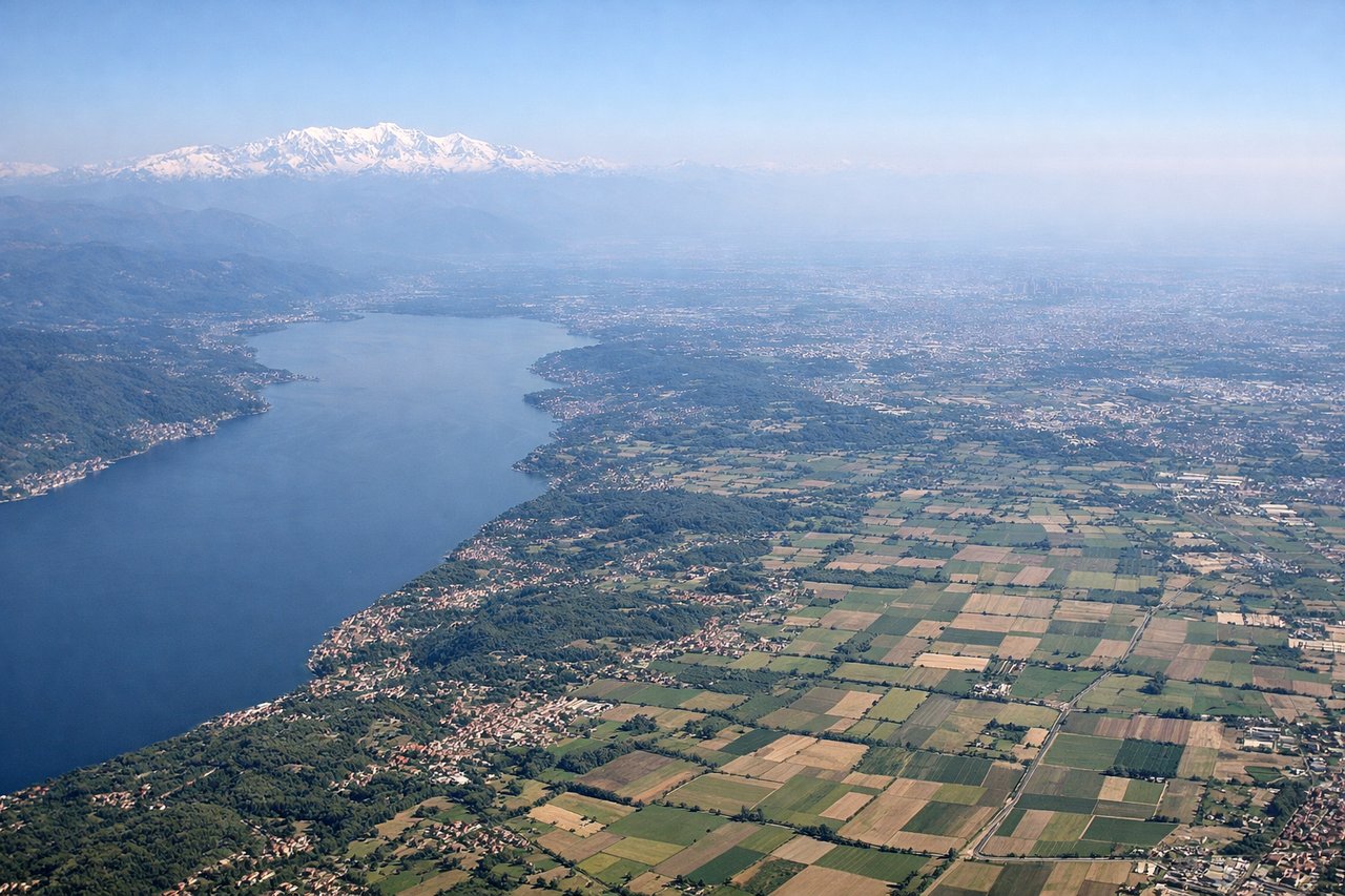 Aerial window seat view during takeoff from Milano (left side) — Western Alps (Monte Rosa, Gran Paradiso massif), Lake Maggiore to the northwest, Ticino River valley, Po River plain stretching southeast