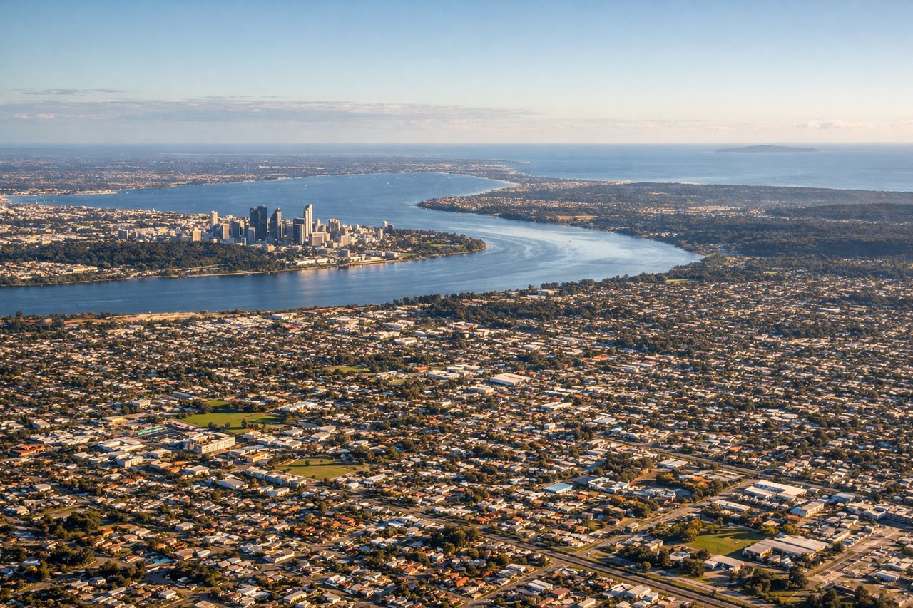 Aerial window seat view during takeoff from Perth (right side) — Swan River estuary and bends through Perth, Perth CBD skyline against the coast, Rottnest Island visible offshore to the northwest, Indian Ocean coastline stretching north toward Scarborough and Trigg
