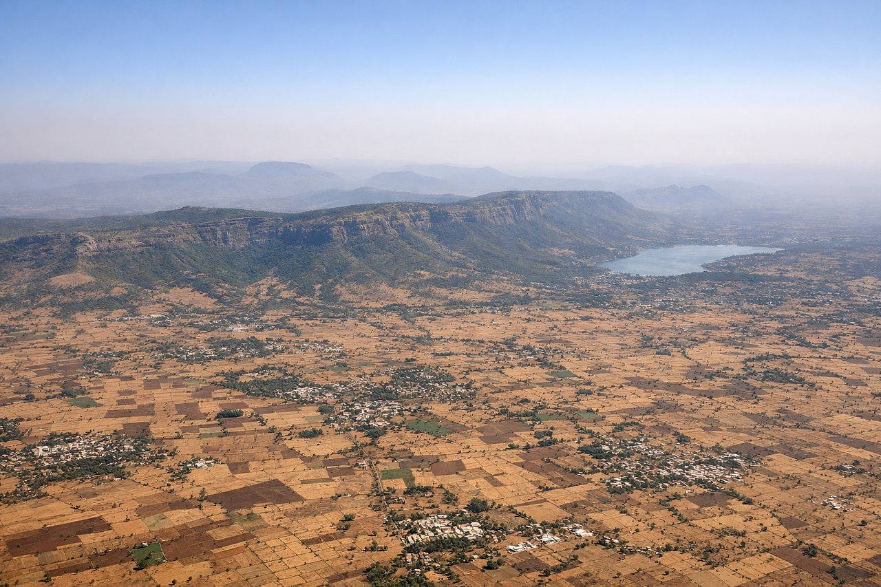 Right window seat view during takeoff from Pune (PNQ) — Western Ghats escarpment (left/north), Pune city sprawl (below/behind), Mula-Mutha River valley system (center-left during climb), Sahyadri peaks on distant horizon (left)