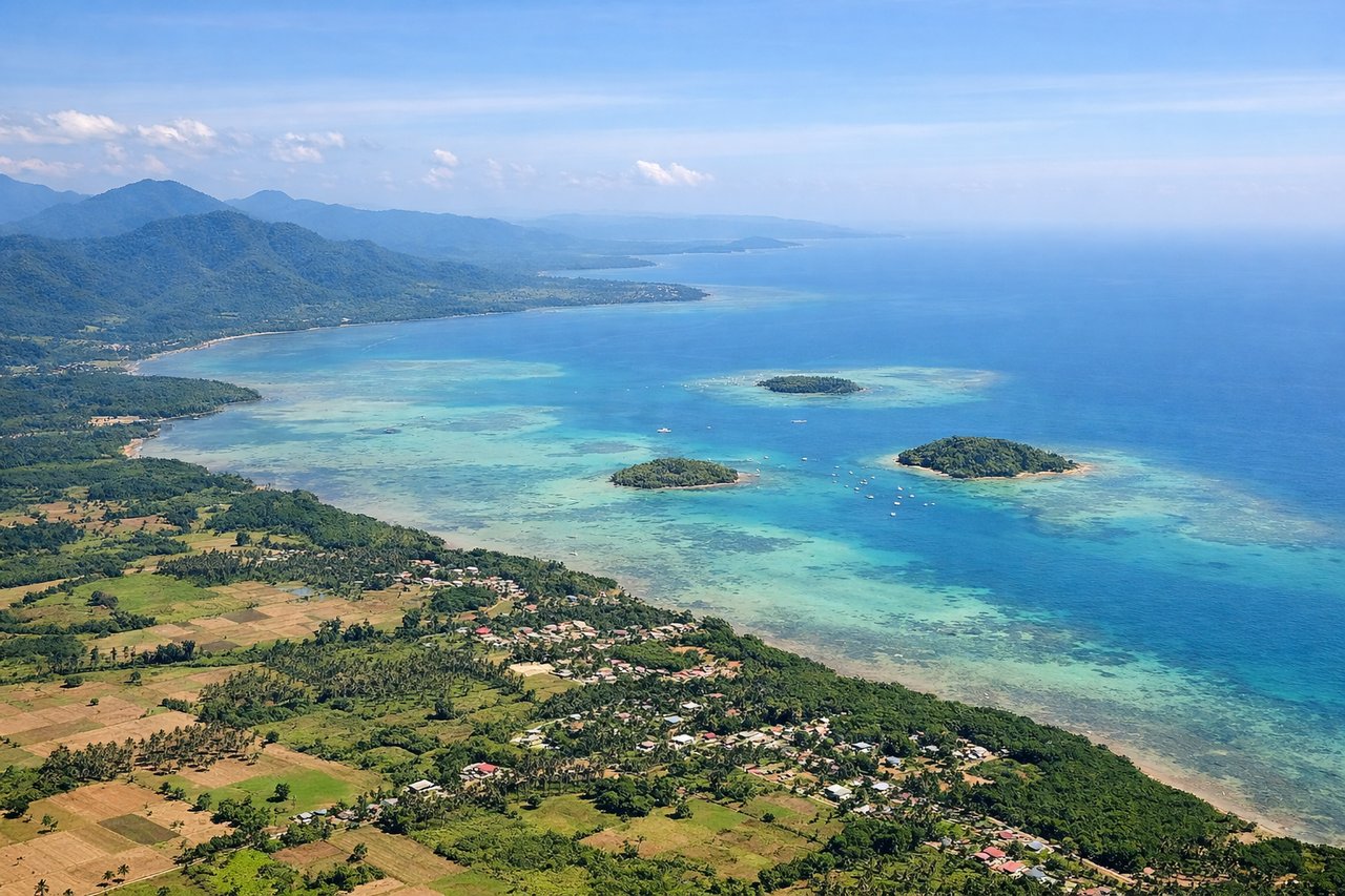 Aerial window seat view during takeoff from Puerto Princesa (right side) — Honda Bay and its scatter of small islands, the eastern Palawan coastline, the Sulu Sea opening to the southeast, forested karst hills east of the city