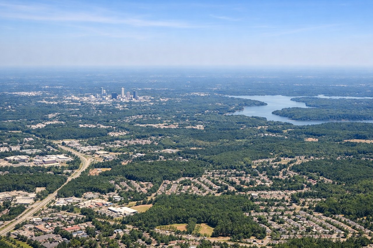 Left window seat view during takeoff from Raleigh-Durham (RDU) — Downtown Durham skyline, Duke University campus, Research Triangle Park, Eno River State Park (farther north on the horizon)