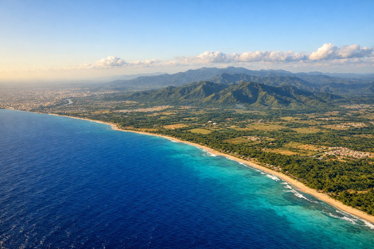 Right window seat view during landing at Santo Domingo (SDQ) — Caribbean coastline, Santo Domingo urban sprawl, Ozama River delta, distant Cordillera Central mountains on the horizon