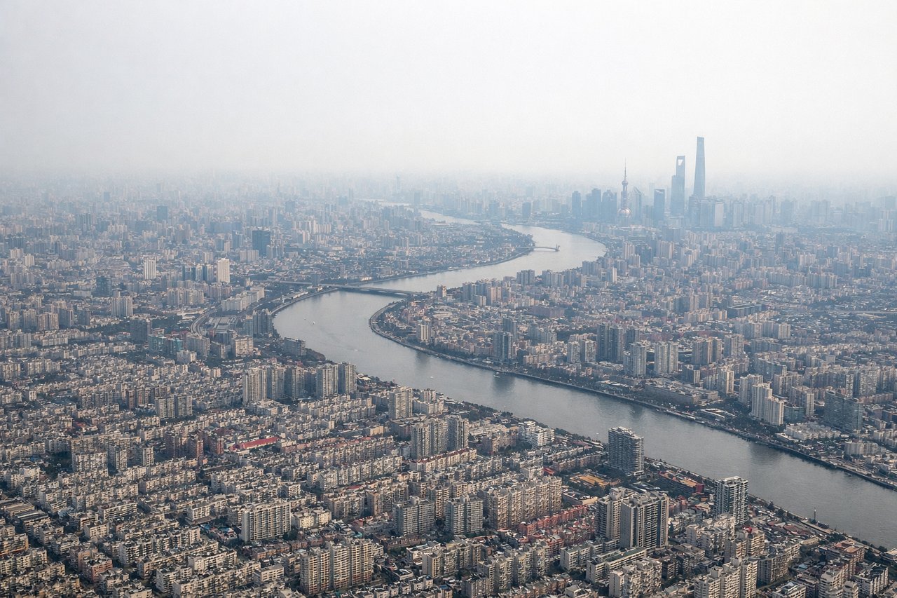 Right window seat view during landing at Shanghai (SHA) — Huangpu River, Pudong skyline (Oriental Pearl Tower, Shanghai Tower, Jin Mao Tower), northern Shanghai suburbs, Hongqiao's dense urban approach corridor
