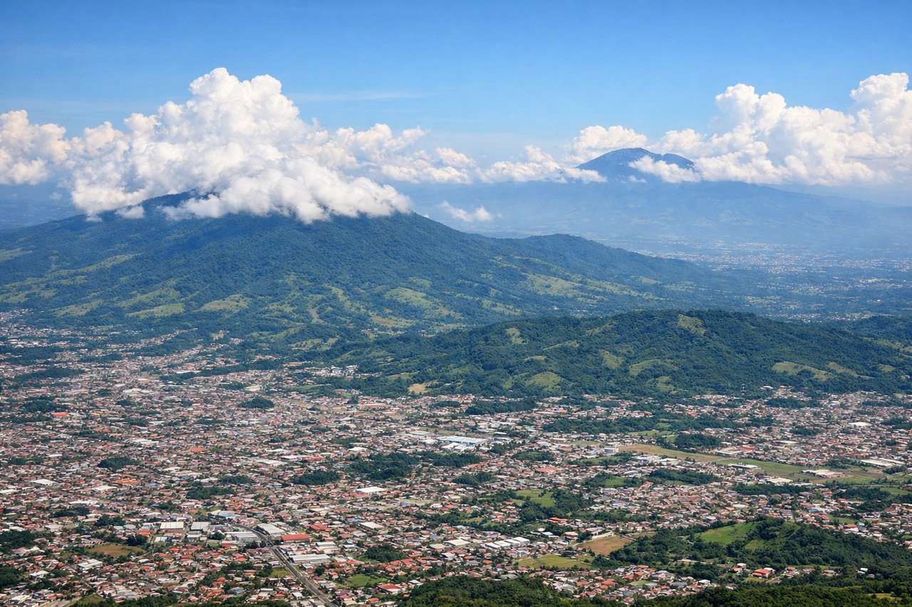 Left window seat view during takeoff from San Jose (SJO) — Poás Volcano, Barva Volcano, Central Valley farmland, Alajuela town