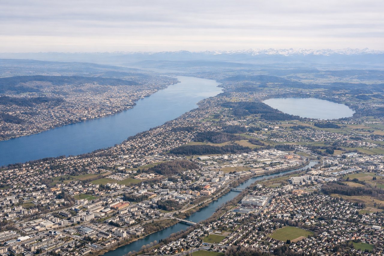 Aerial window seat view during takeoff from Zurich (left side) — Lake Zurich, Zurich city center, Albis ridge, distant Glarus Alps