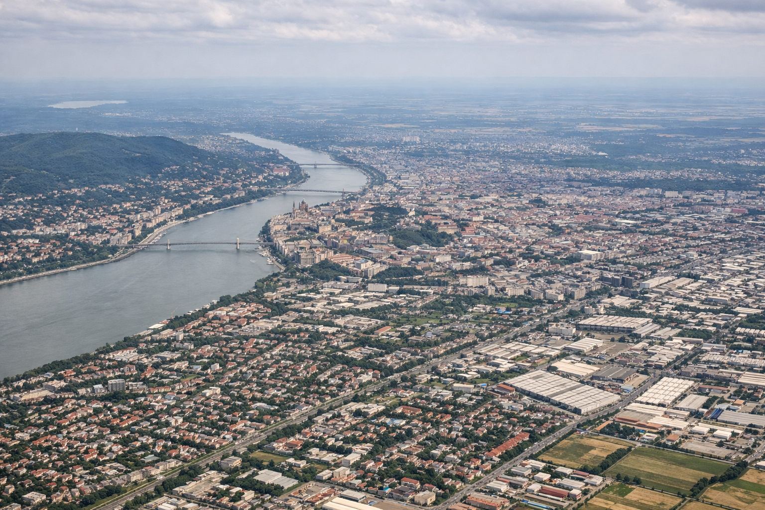 Aerial window seat view during takeoff from Budapest (right side) — Danube River bend, Buda Castle Hill, Hungarian Parliament Building, Budapest downtown skyline