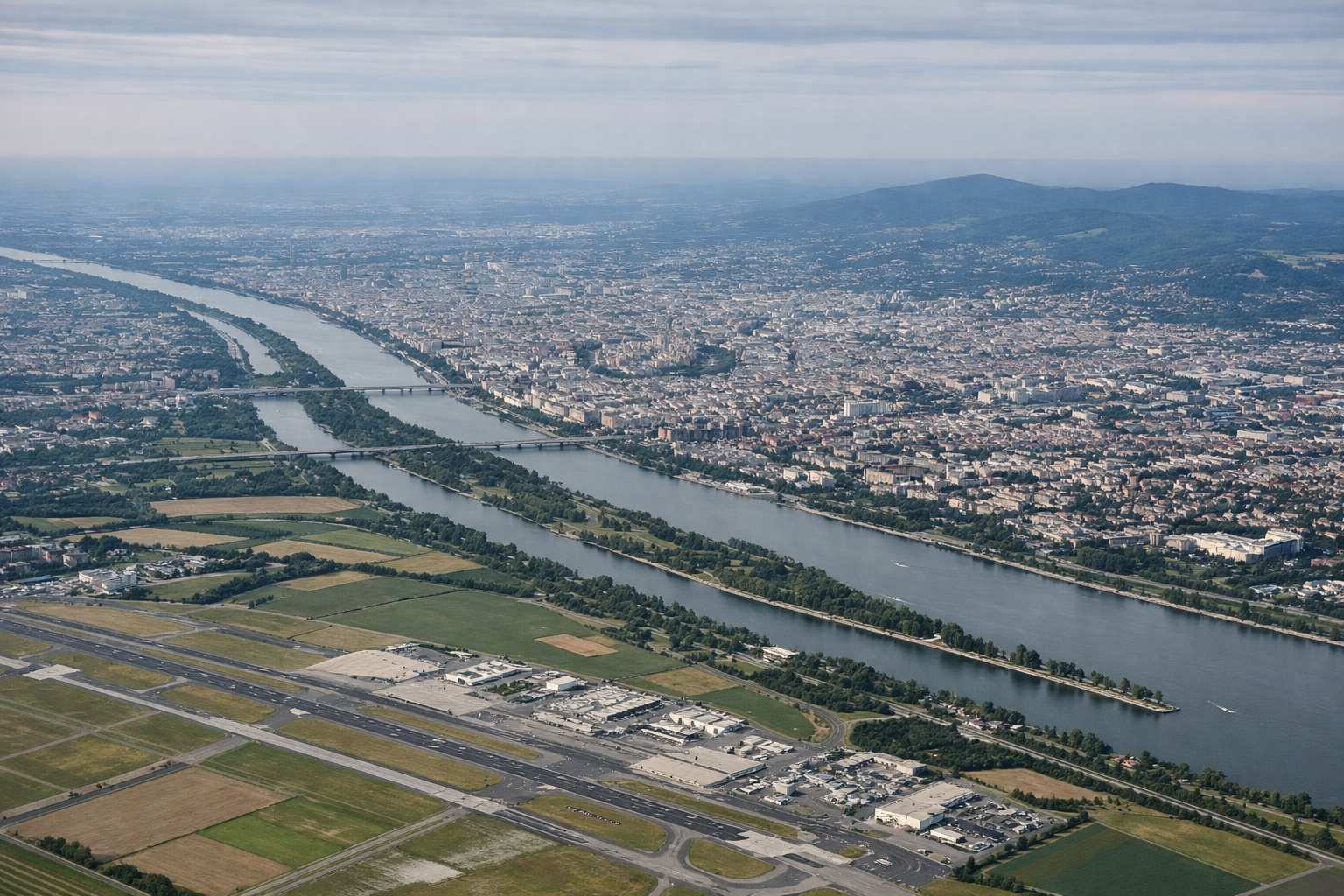 Aerial window seat view during takeoff from Vienna (right side) — Danube River, Vienna city outskirts, Vienna Woods foothills, Lower Austrian farmland